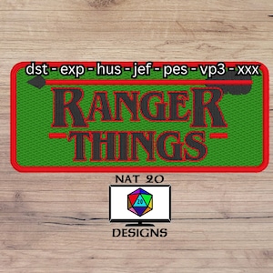 Op de afbeelding: Een groene en rode geborduurde patch met de tekst "RANGER THINGS" in zwart. De patch heeft een rode rand en de tekst "dst - exp - hus - jef - pes - vp3 - xxx" bovenaan. Onder de patch bevindt zich een wit computerscherm met de tekst "NAT 20 DESIGNS" en een kleurrijke 20-zijdige dobbelsteen.