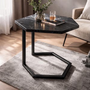 May include: A contemporary side table with a black marble hexagonal top and a black metal frame. The table is set on a grey rug. A glass of liquid, a book, and a vase with greenery are on the table. The table's dimensions are approximately 70 cm.