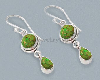May include: A pair of silver dangle earrings featuring green turquoise stones. The stones are round and have a mottled pattern. The earrings have a teardrop shape.