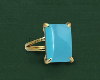 May include: A gold ring with a light blue rectangular gemstone.