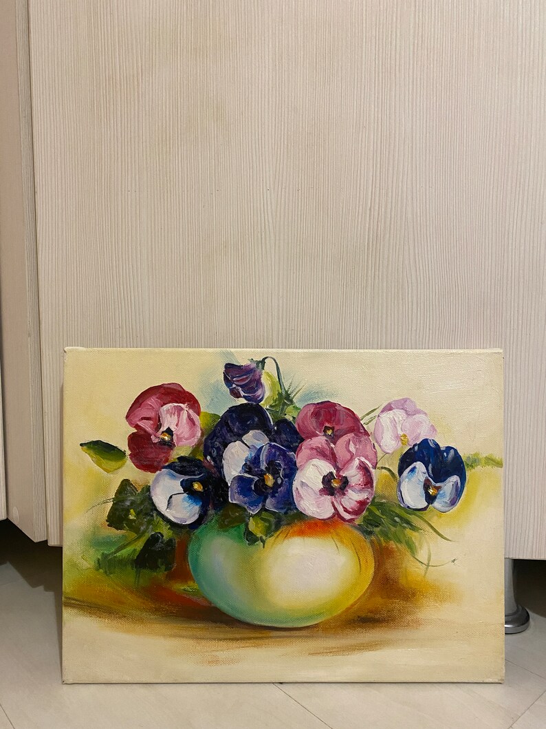 May include: A painting of a bouquet of purple, pink, and white pansies in a green vase. The pansies are arranged in a loose, natural style, and the vase is simple and elegant. The background is a soft yellow.