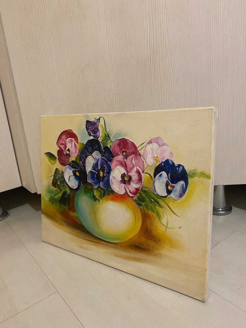 May include: A painting of a bouquet of purple, pink, and white pansies in a green vase. The pansies are arranged in a loose, natural style, and the vase is a simple, rounded shape. The background is a soft, yellow-toned canvas.