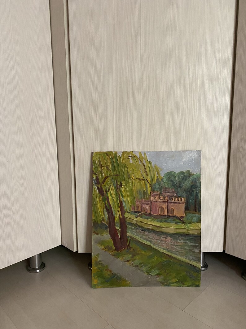 May include: A painting depicting a pink building with a moat and a weeping willow in the foreground. The building has a green roof and is surrounded by green trees. The painting is executed in a realistic style.