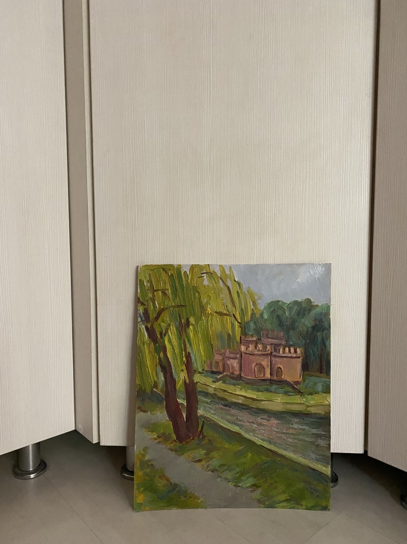 May include: A painting depicting a landscape with a river, a building, and a weeping willow tree. The building is a pale pink colour and has a few windows. The weeping willow tree is in the foreground and has green leaves. The river is in the background and is a light blue colour.