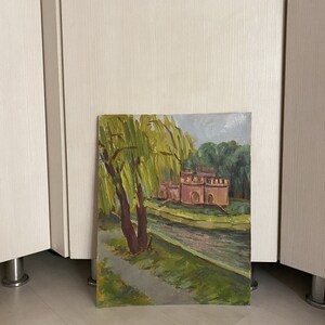 May include: A painting depicting a castle with a moat and a weeping willow tree in the foreground. The castle is painted in shades of pink and brown, and the willow tree is green. The painting is executed in a realistic style.