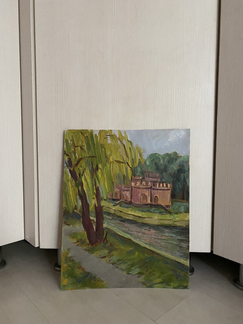 May include: A painting depicting a landscape with a small castle in the background, a river in the foreground, and a weeping willow tree on the left side of the painting.