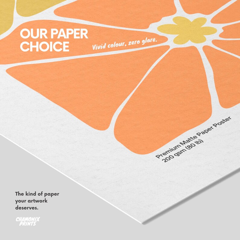 May include: A premium matte paper poster with a 200 gsm (80 lb) weight, featuring a graphic orange and yellow flower design. Text on the poster reads: OUR PAPER CHOICE, Vivid colour, zero glare, Premium Matte Paper Poster, and The kind of paper your artwork deserves. Chamonix Prints logo is visible.