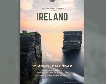 May include: A 12-month wall calendar featuring fine art photography from Ireland. The cover displays a sunset over dark coastal cliffs and the ocean. Text includes FINE ART PHOTOGRAPHY FROM IRELAND, 12 MONTH CALENDAR, and CHAMONIX PRINTS.