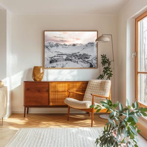 Framed Tignes ski resort print above mid-century sideboard in sunlit living room