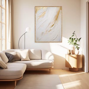 Minimalist gold and white wall print above cream couch with plant.