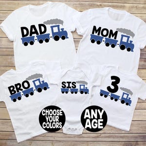 May include: White t-shirts with black text and blue train graphics. The shirts read "DAD", "MOM", "BRO", "SIS", and "3". A baby onesie is also included. The image also includes the text "CHOOSE YOUR COLORS" and "ANY AGE".