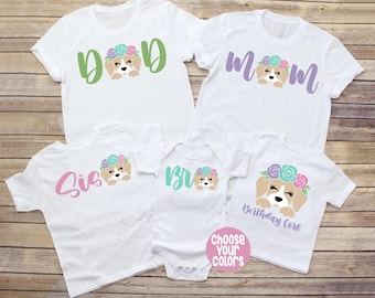 Può includere: T-shirt bianche e un body con grafica di cani e testo. Le magliette riportano le scritte "Dad", "Mom", "Sis", "Bro" e "Birthday Girl". È visibile anche il testo "Choose Your Colors".