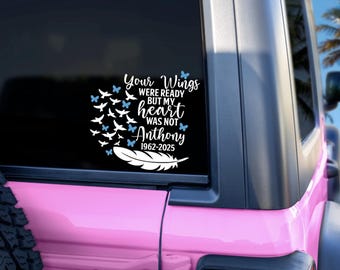 May include: A white decal on a vehicle window with the text "Your Wings Were Ready But My Heart Was Not Anthony 1962-2025". The design includes butterflies, birds, and a feather.