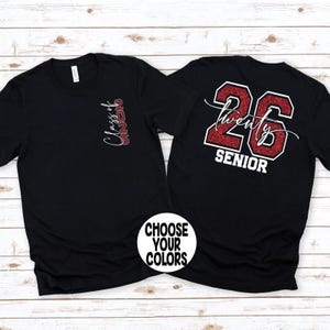 May include: Black t-shirts with red glitter text. One shirt has "Class of 2026" vertically on the front. The other shirt has "Twenty 26 SENIOR" on the back. A white circle with "CHOOSE YOUR COLORS" is in the image.