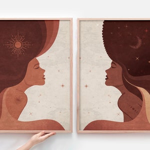 Puede incluir: Dos impresiones enmarcadas con ilustraciones abstractas de rostros de mujeres. La primera impresión presenta a una mujer con un sol sobre su cabeza y un fondo marrón, naranja y beige. La segunda impresión presenta a una mujer con estrellas en el pelo y un fondo marrón, naranja y beige.