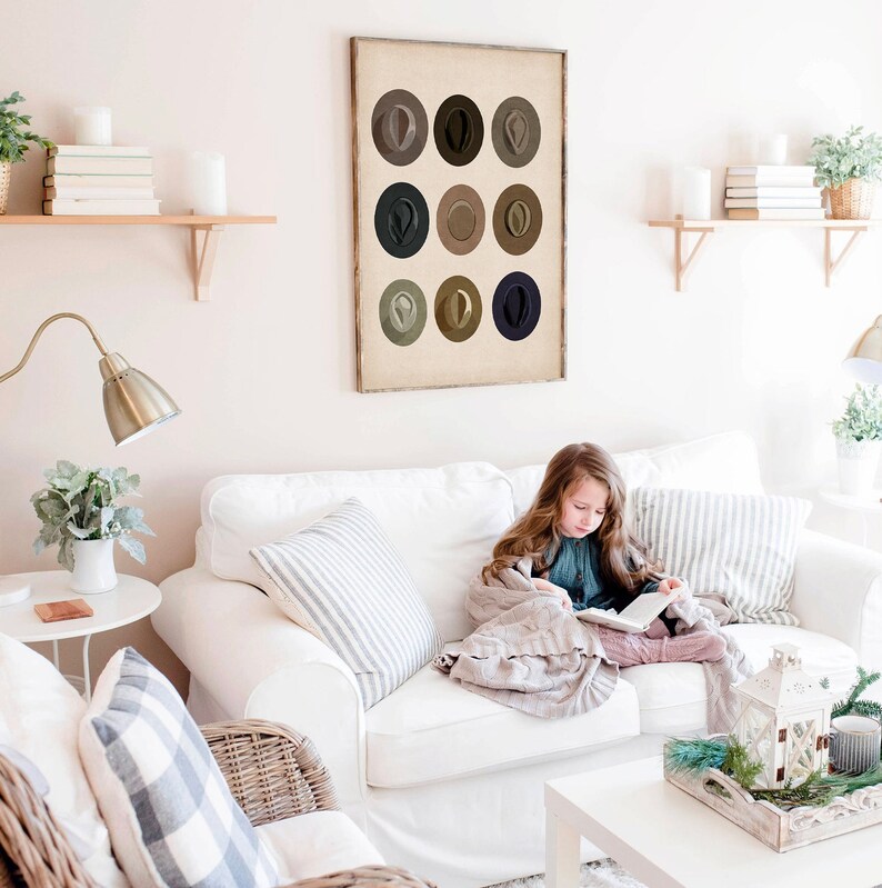 May include: A framed print of nine brown, gray, and blue circles arranged in a grid. The circles are all the same size and are evenly spaced. The print is hanging on a white wall in a living room.