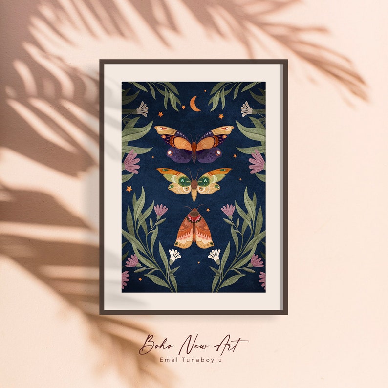 May include: A framed print with a dark blue background featuring three colorful moths and butterflies with a crescent moon and stars. The print is surrounded by green leaves and pink flowers.