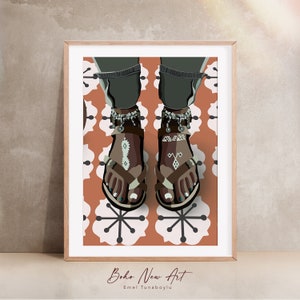 May include: Illustration of feet wearing brown sandals with decorative patterns and ankle bracelets. The artwork is set against a patterned background of white and orange flowers. The framed print is labeled "Boho New Art" and the artist's name.