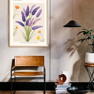May include: A framed botanical illustration of purple flowers with yellow flowers and green leaves. The frame is light wood and the illustration has the text "FLOWER MARKET PARIS FRANCE" at the top and "BOND FLOWERS OF CIVES - CURATED ART COLLECTION" at the bottom.