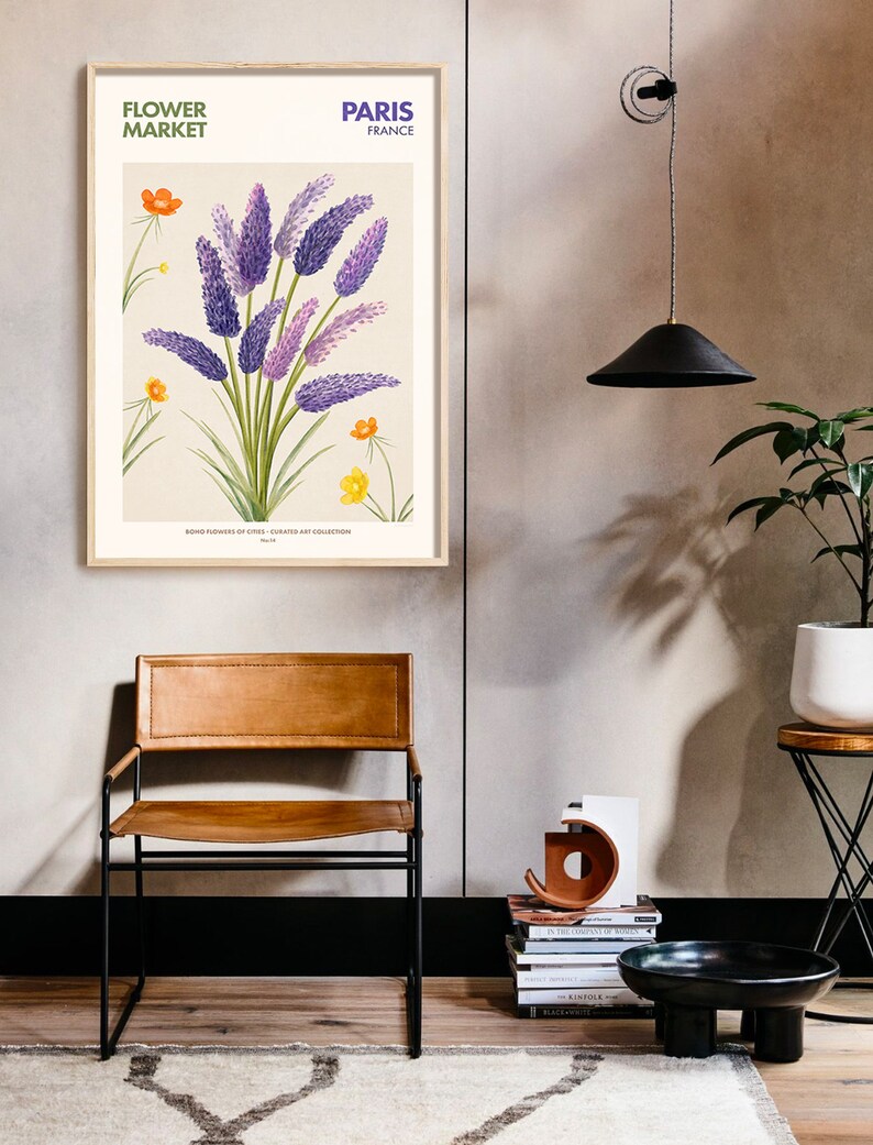 May include: A framed botanical illustration of purple flowers with yellow flowers and green leaves. The frame is light wood and the illustration has the text "FLOWER MARKET PARIS FRANCE" at the top and "BOND FLOWERS OF CIVES - CURATED ART COLLECTION" at the bottom.