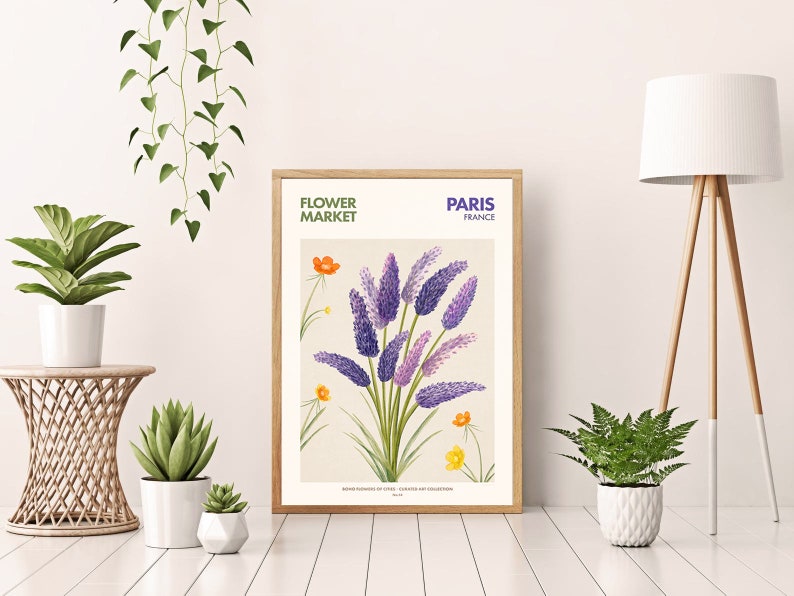 May include: A framed botanical illustration of purple flowers with green leaves and yellow flowers. The frame is wood with a white mat. The text on the frame reads "FLOWER MARKET PARIS FRANCE".