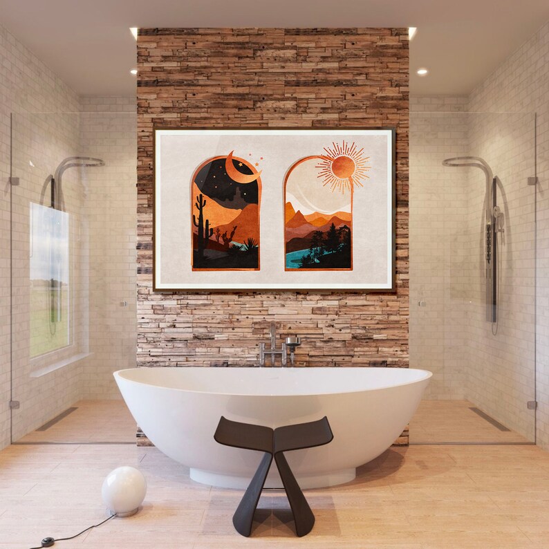 Op de afbeelding: Een wit bad met een zwarte kruk ervoor. Een ingelijst afdruk van twee ramen met een woestijnlandschap en een zon en maan in elk raam hangt aan een bakstenen muur achter het bad.