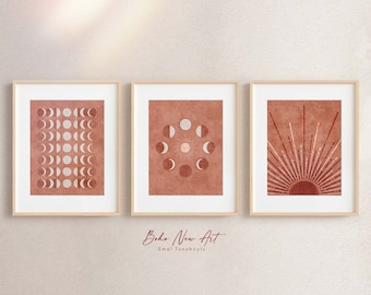 May include: Three framed prints with a boho aesthetic. The prints feature a moon phase design in shades of red and white. The text "Boho New Art" and "Emel Tunaboylu" is visible below the prints.