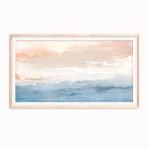 May include: Abstract painting with a soft, dreamy feel. The painting features a light pink and beige sky with white clouds, and a blue and gray ocean. The painting is framed in a light wood frame.
