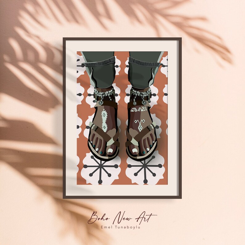 May include: Framed art print featuring a stylized illustration of feet wearing brown sandals with decorative anklets. The sandals have turquoise accents and are set against a patterned background. The artwork is signed "Boho New Art" by Emel Tunaboylu.