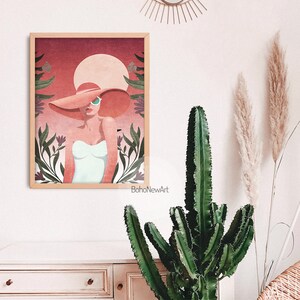 May include: A digital illustration of a woman wearing a large, wide-brimmed hat and sunglasses. The woman is standing in front of a pink and red background with green foliage and flowers. The text "BohoNewArt" is at the bottom of the image.