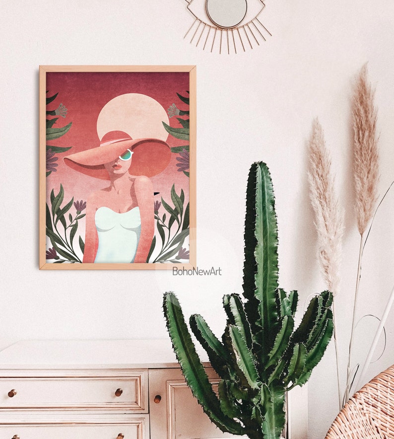 May include: A digital illustration of a woman wearing a large, wide-brimmed hat and sunglasses. The woman is standing in front of a pink and red background with green foliage and flowers. The text "BohoNewArt" is at the bottom of the image.