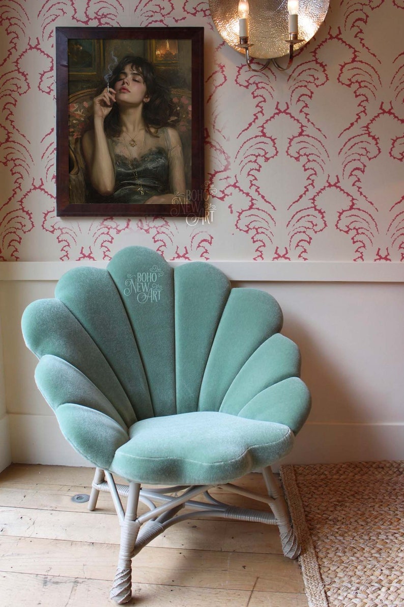 May include: A teal blue velvet chair with a shell-shaped back and white wicker legs. The chair is in front of a white wall with pink floral wallpaper. The chair is in a room with a wooden floor.