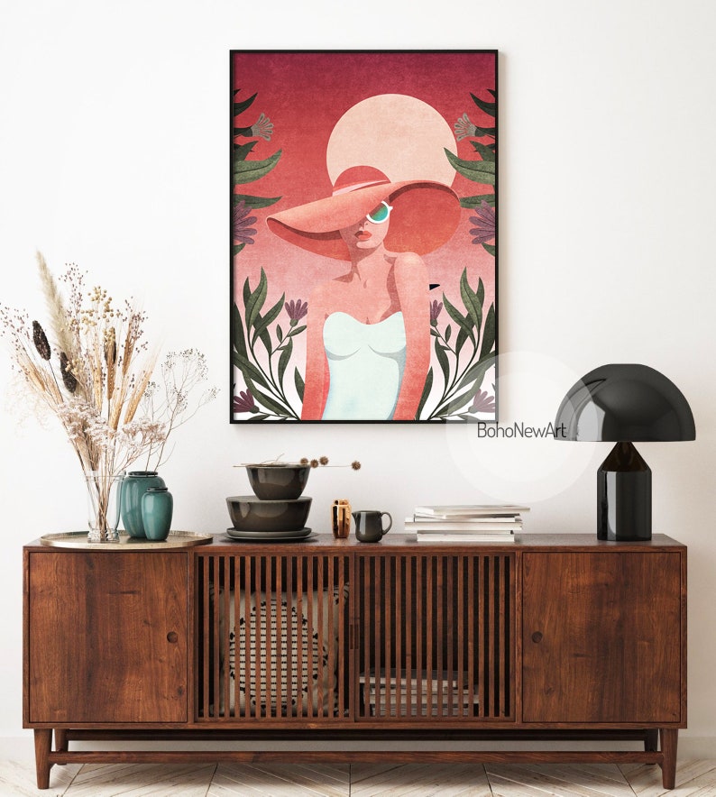 May include: A digital illustration of a woman wearing a large pink hat and sunglasses, standing in front of a red and pink sunset with green foliage.