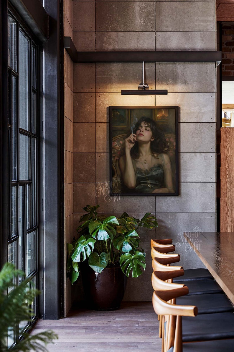 May include: A painting of a woman with dark hair, wearing a dark blue dress, holding a cigarette, hanging on a gray wall in a restaurant setting. There is a potted plant in the corner and a wooden table with chairs in the foreground.