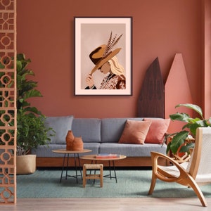 May include: A framed illustration of a woman wearing a brown hat with feathers and a patterned blouse. The background is a light peach color.