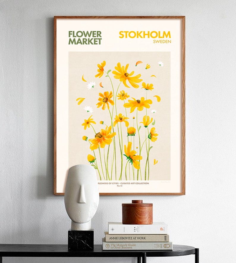 May include: A framed poster with a watercolor illustration of yellow flowers on a beige background. The poster has the text "FLOWER MARKET" and "STOKHOLM SWEDEN" at the top. The text "FLOWERS OF CITIES - CURATED ART COLLECTION" is at the bottom.