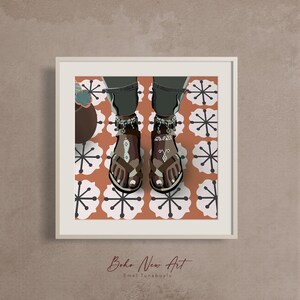 May include: Illustration of feet wearing brown sandals with decorative silver anklets, paired with dark jeans. The sandals have intricate patterns and are set against a background of a patterned orange and white floor. The artwork is framed and signed.
