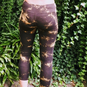 Könnte beinhalten: Eine Person trägt einen braunen und gelben Batik-Sport-BH mit Kreuzrücken und dazu passende Batik-Leggings.