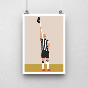 May include: A black and white striped soccer jersey with a player holding a black jersey above their head. The player is wearing red shoes and has blonde hair.