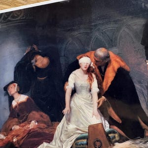 May include: A historical painting depicts a woman in a white gown, blindfolded, surrounded by figures in dark clothing and a man in a fur-trimmed robe. The scene evokes a sense of drama and historical context, with a focus on the central figure.