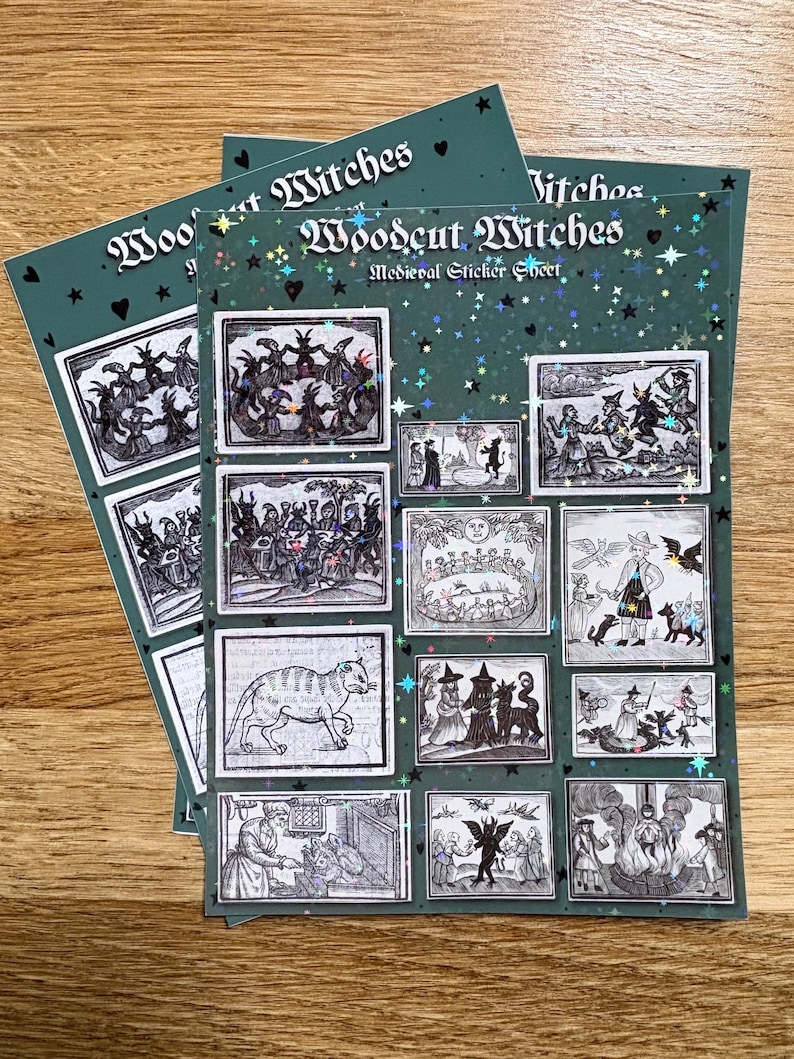 May include: A stack of "Woodcut Witches" medieval sticker sheets. Each sheet is dark teal with a glittery finish and features multiple black and white illustrations of witches and medieval scenes. The text "Woodcut Witches" is printed at the top.