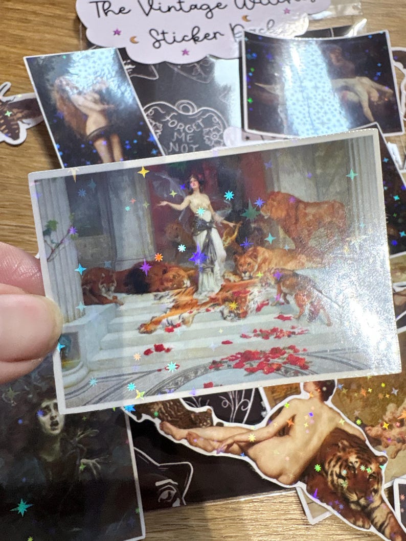 Puede incluir: Una pegatina rectangular con una pintura cl&aacute;sica de una figura con vestido blanco rodeada de leones y tigres en escalones de piedra, superpuesta con un patr&oacute;n de estrellas hologr&aacute;ficas. Incluye p&eacute;talos de flores rojas esparcidos.