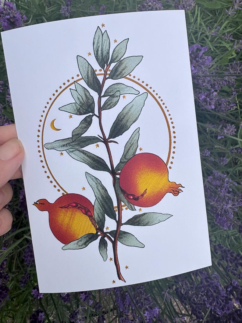 Pu&ograve; includere: Una stampa artistica rettangolare su carta bianca con un'illustrazione centrale di un ramo di melograno con due frutti maturi rossi e gialli e foglie verdi. Un cerchio dorato punteggiato circonda il ramo, accentato da piccole stelle e luna.