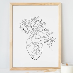 Könnte beinhalten: Gerahmter Kunstdruck mit einer schwarz-weißen Strichzeichnung eines menschlichen Herzens, aus dem ein Baum wächst. Das Kunstwerk befindet sich in einem hellen Holzrahmen, mit einer Kerze in der Nähe.