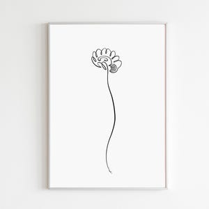 May include: A minimalist black line drawing of a flower on a white background, framed in a silver border. The artwork features a single, continuous line forming the flower's head and stem, creating a simple yet elegant botanical illustration.
