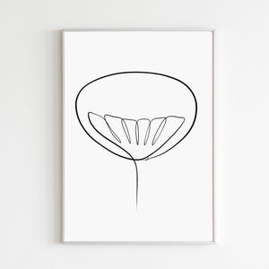 May include: A framed minimalist art print featuring a black line drawing of a flower. The artwork depicts a single, continuous line forming the outline of a flower with a large, oval-shaped head and delicate petals. The print is set against a white background.