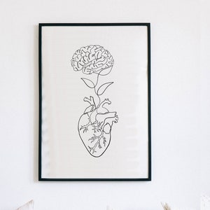 May include: A black and white line drawing of a brain growing from a heart. The image is framed in a black frame and hanging on a white wall.