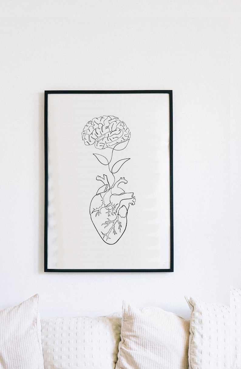 May include: A black and white line drawing of a brain growing from a heart. The image is framed in a black frame and hanging on a white wall.