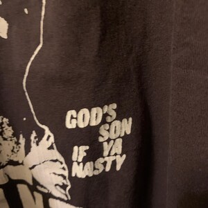 May include: Black t-shirt with white text that reads "God's Son If Ya Nasty".