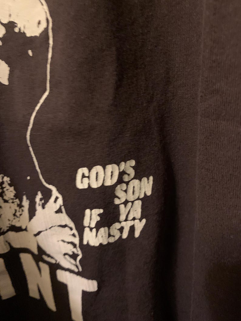 May include: Black t-shirt with white text that reads "God's Son If Ya Nasty".